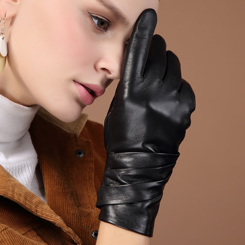 Black leather women’s glove with curved knuckle shape and pleated cuff seam