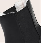 Close-up of black boot's elastic side panel and soft faux fur lining