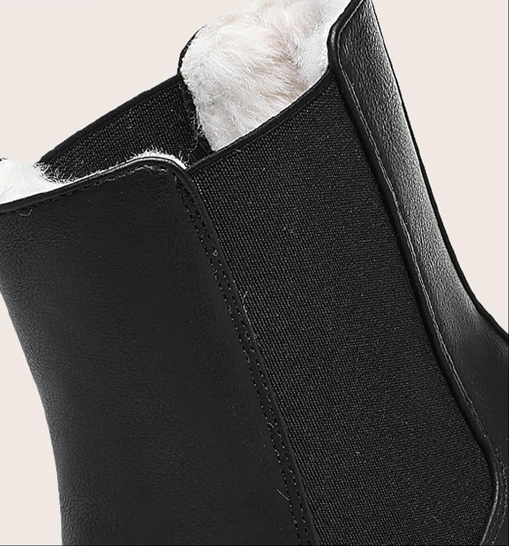 Close-up of black boot's elastic side panel and soft faux fur lining