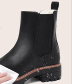 Black faux leather boot with elastic side panel and contrast welt, shown being wiped clean