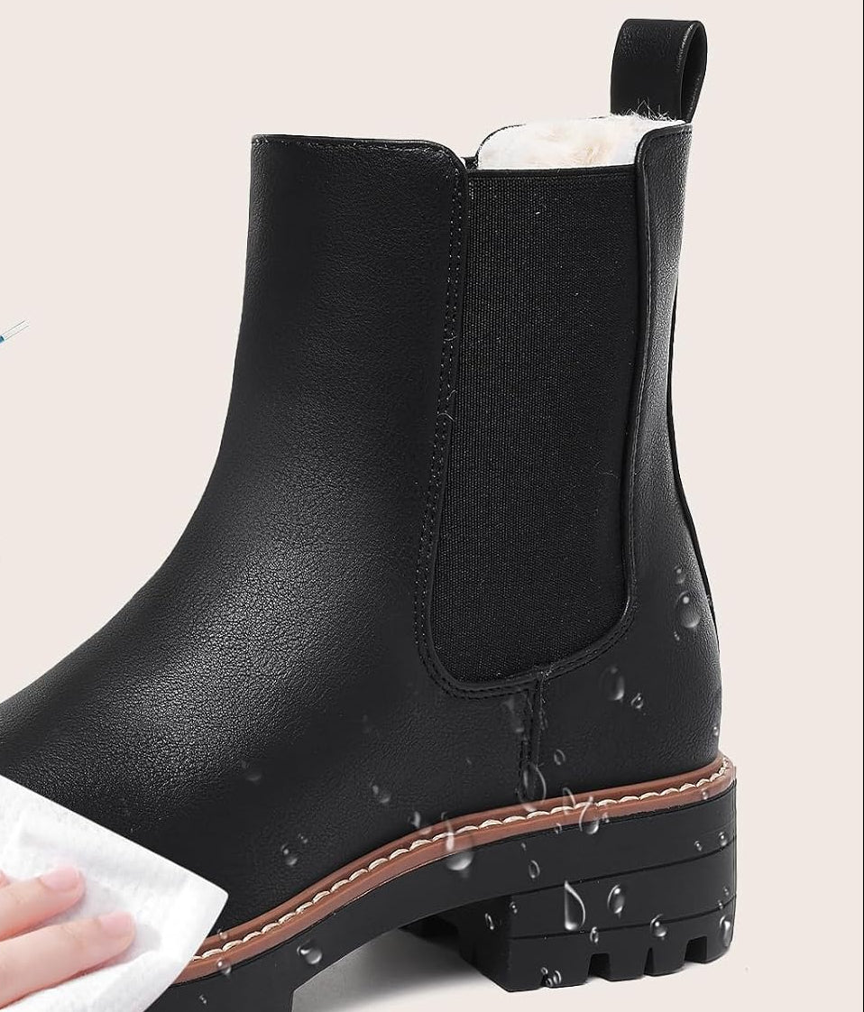 Black faux leather boot with elastic side panel and contrast welt, shown being wiped clean