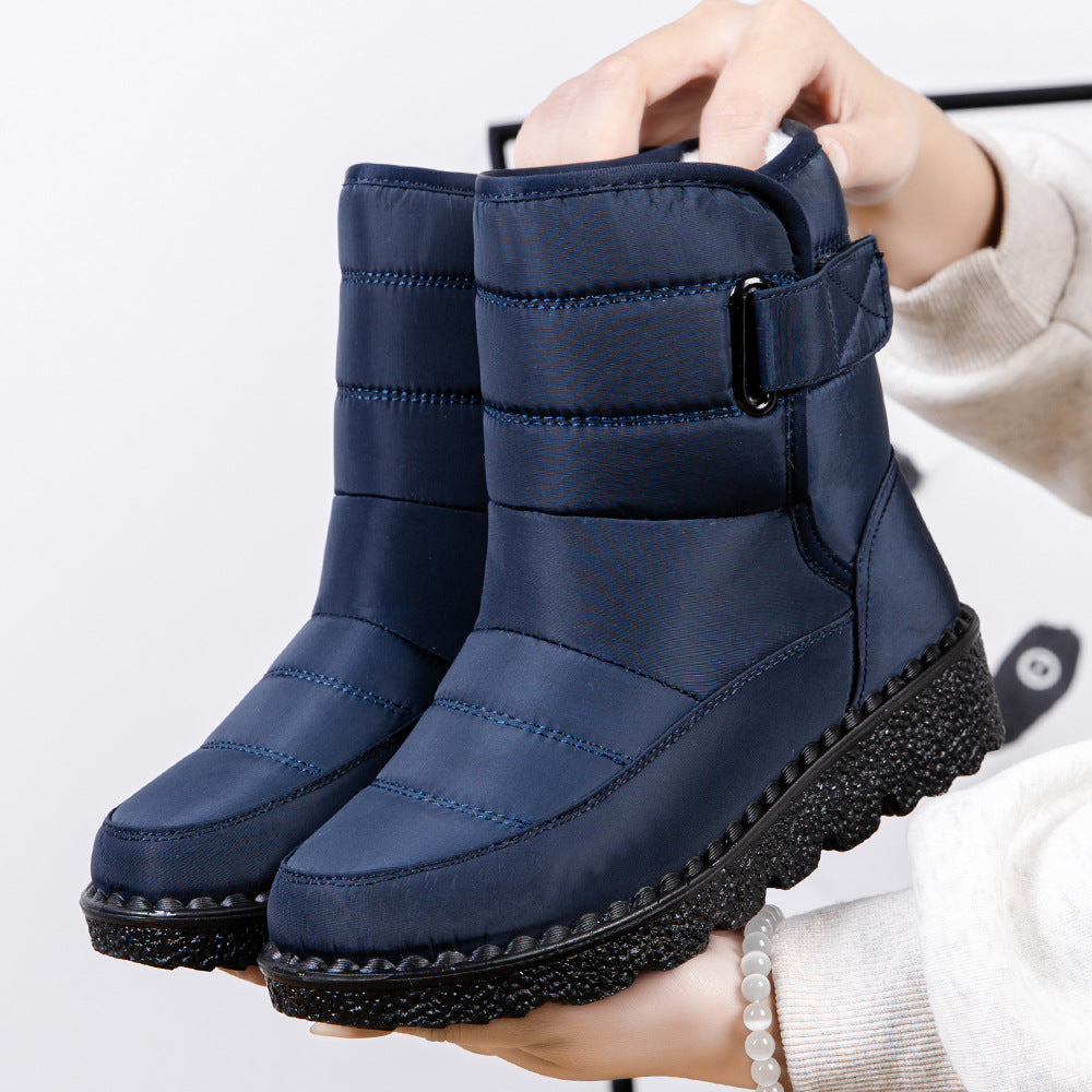 Navy quilted platform puffer snow boots with padded collar and adjustable side strap.