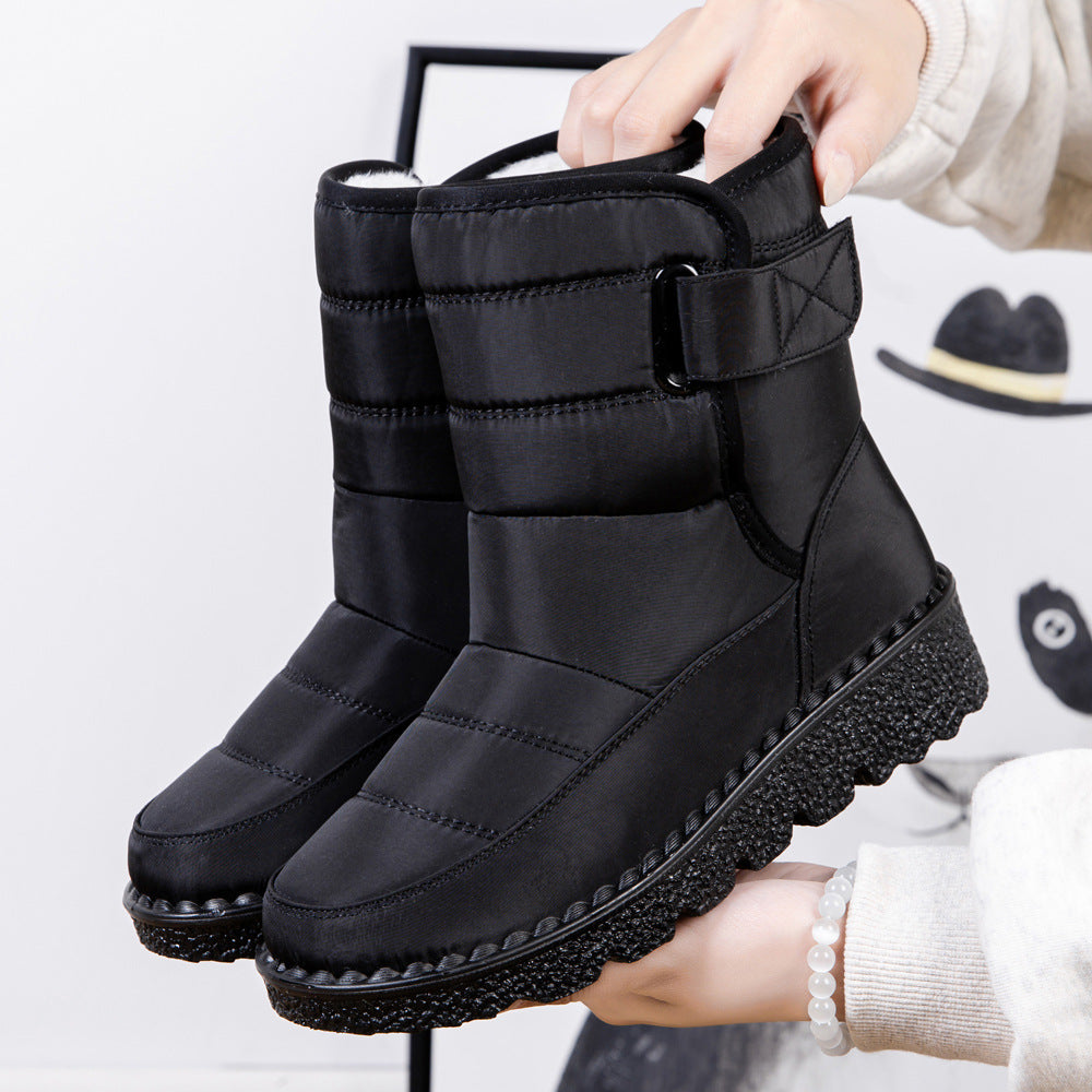 Black quilted platform puffer snow boots with padded collar and adjustable side strap.