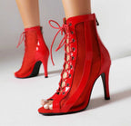 Red peep-toe lace-up stiletto ankle booties with sheer side panels and open toe.