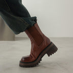 Brown leather Chelsea boots with elastic side panels and chunky tread sole, round toe
