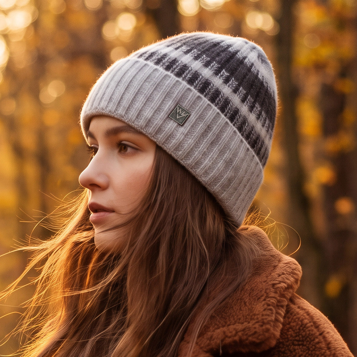 Striped knit beanie in light gray with dark stripes and small metal badge