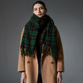 Green plaid scarf with fringed ends, draped around shoulders
