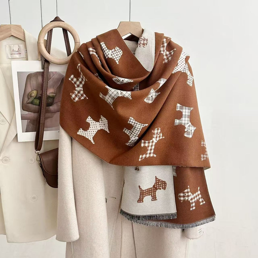 Rust-brown dog-print blanket scarf with a light reverse and fringed ends, draped over a coat