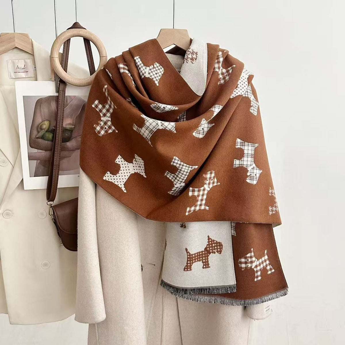 Rust-brown dog-print blanket scarf with a light reverse and fringed ends, draped over a coat