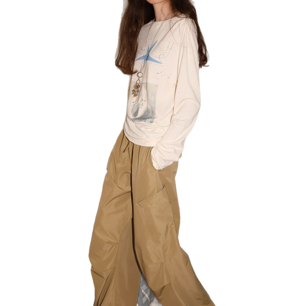 Cream long-sleeve graphic tee with blue star artwork, relaxed fit crew neck