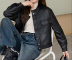 Black faux leather moto jacket with band collar, snap front, and chest flap pocket