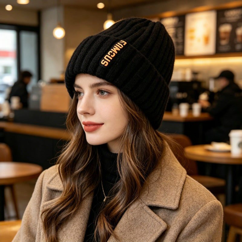 Chunky ribbed beanie in black with folded cuff and letter patch