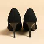 Pair of women's pointed-toe knit stiletto pumps, black, rear heel view