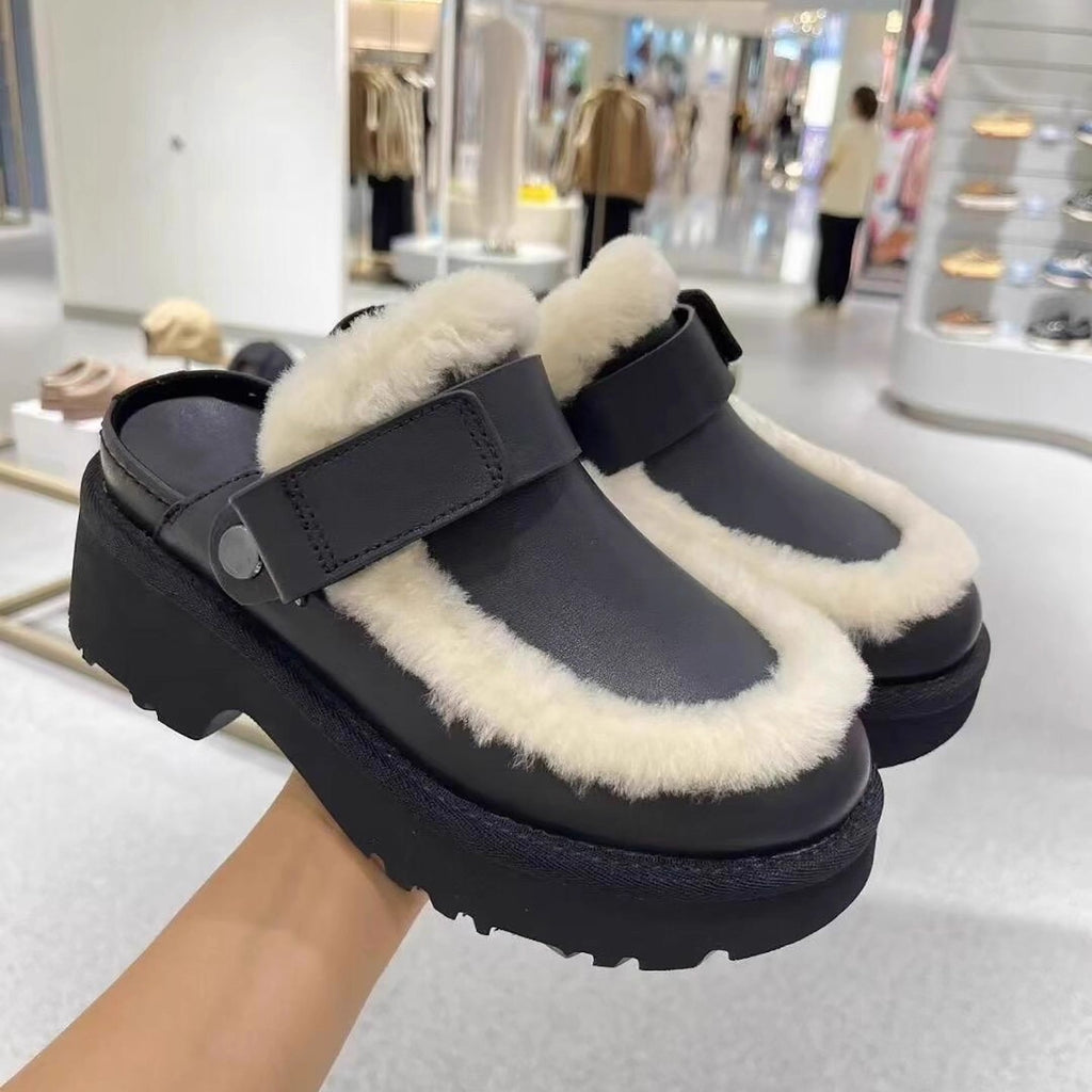 Black furry slip-on slippers with Velcro strap and chunky lug sole.