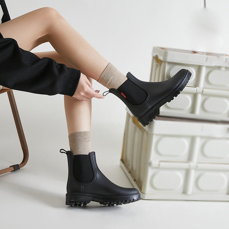 Women's black short chelsea rain boots with elastic side panels and lug sole