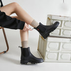 Women's black short chelsea rain boots with elastic side panels and lug sole