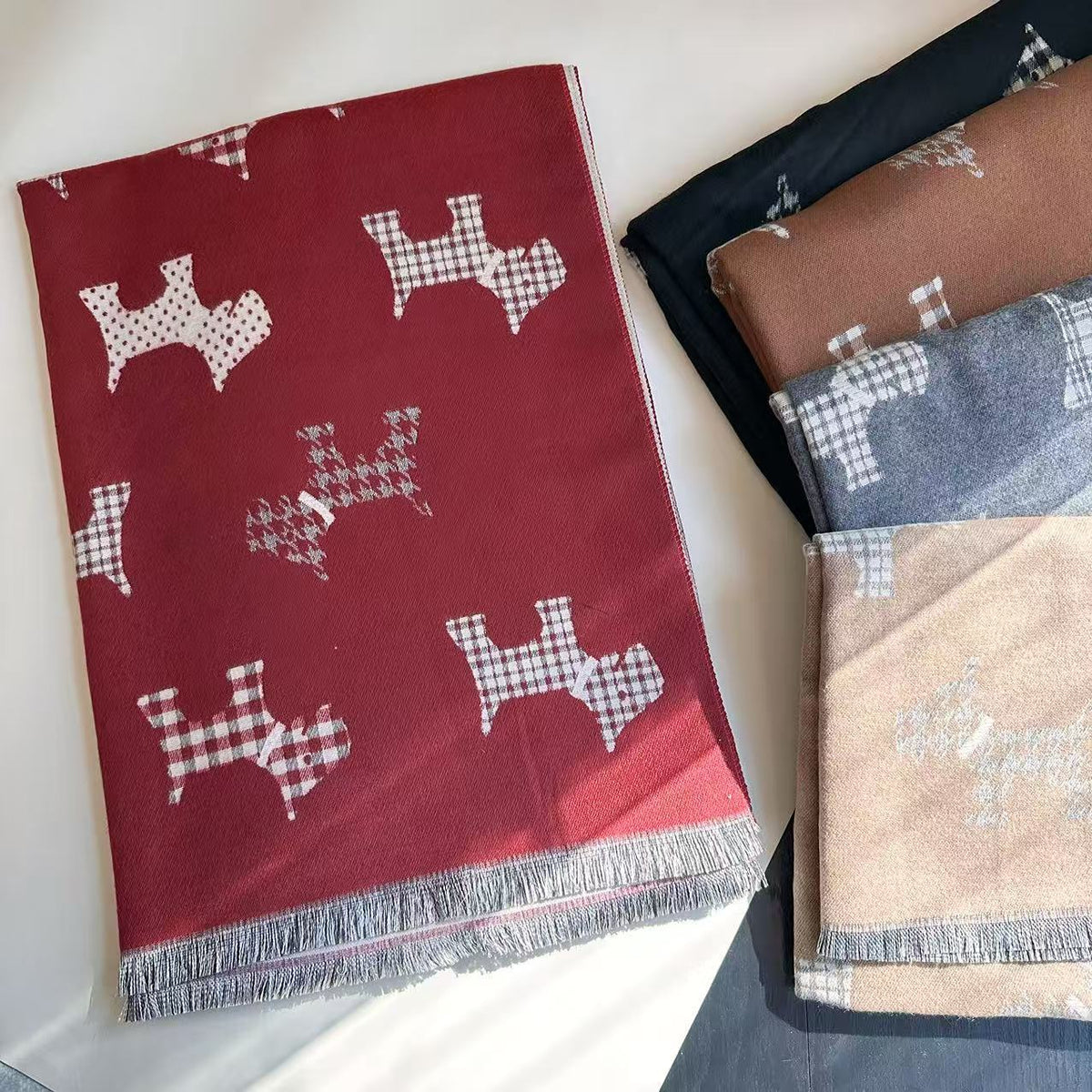 Red dog-print blanket scarf with fringe, shown beside folded color options