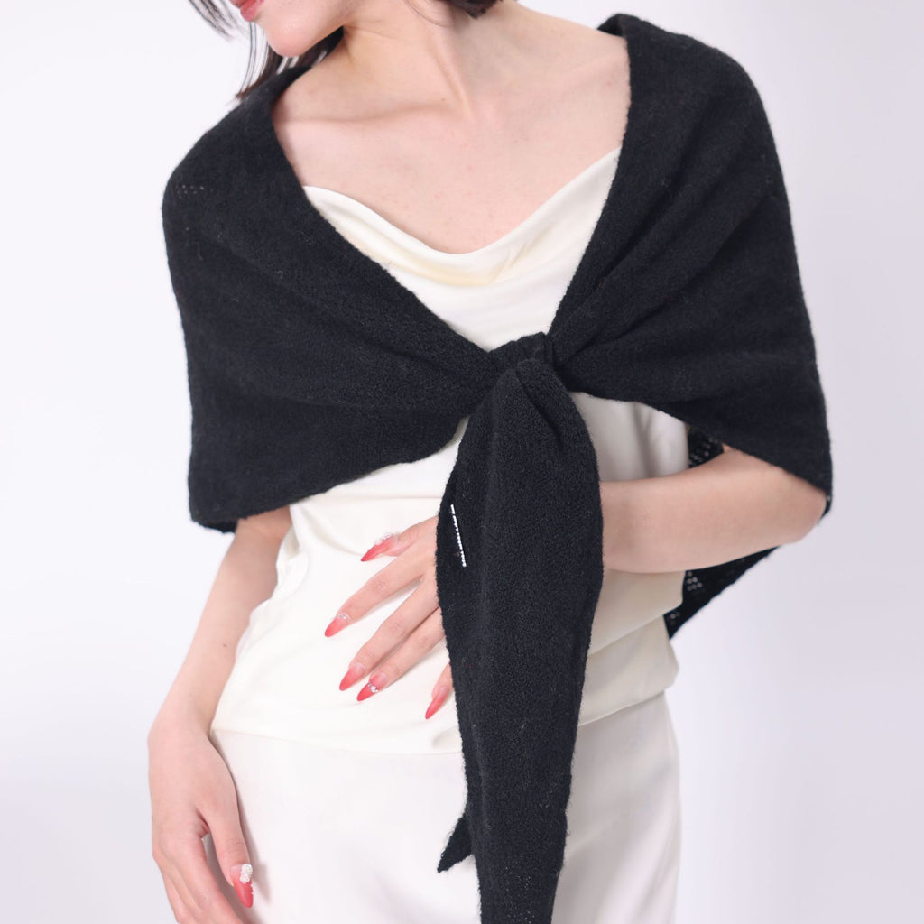 Black knit triangle scarf worn over the shoulders and tied at the front.