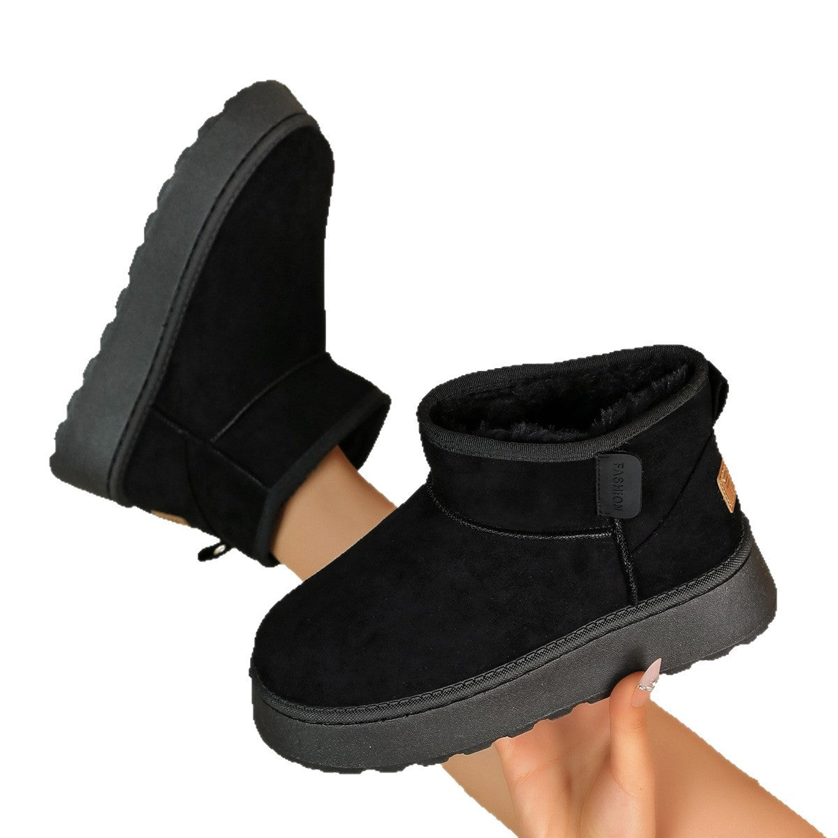 Women’s black suede short snow boots with ankle strap and thick, textured rubber sole