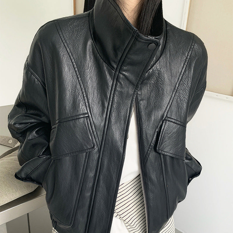 Cropped dark faux leather jacket with stand collar and zip front, flap pockets