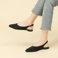 Woven pointed-toe slingback flats with thick sole, black, on feet with denim hem