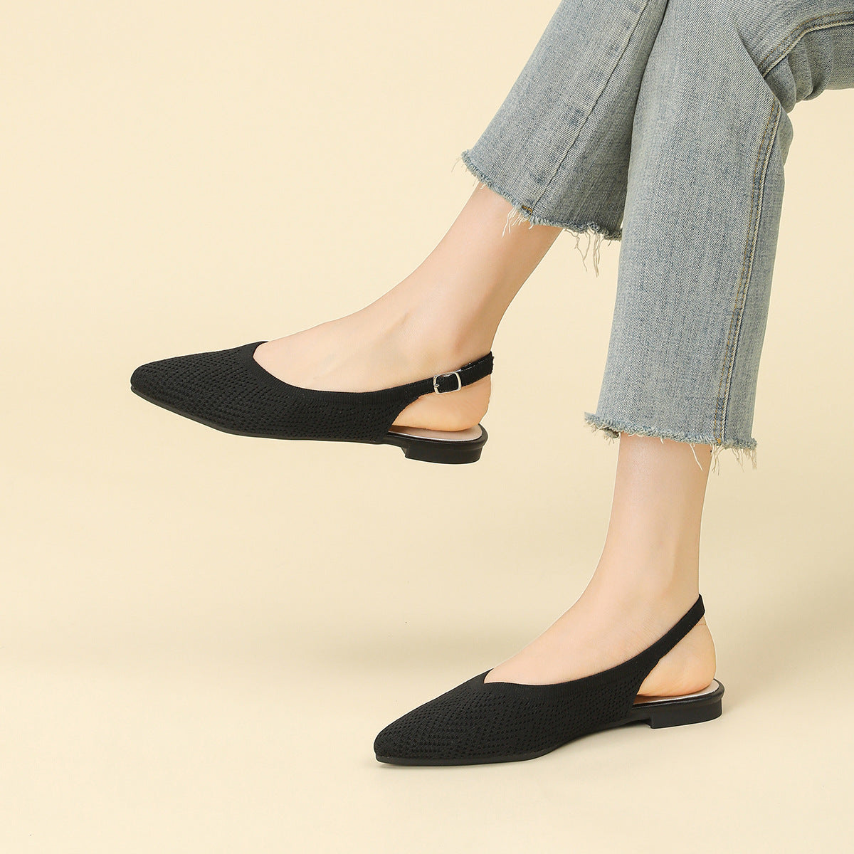 Woven pointed-toe slingback flats with thick sole, black, on feet with denim hem