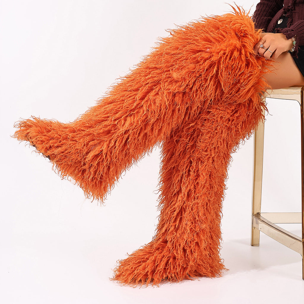 Orange shaggy faux fur thigh-high boots, one leg extended.