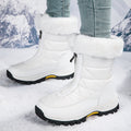 White mid-calf zip-up snow boots with quilted panels, faux fur cuff, lug sole.