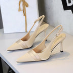 Beige satin slingback heels with pointed toe, stiletto heel, and folded vamp band.