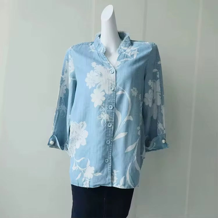 Light blue sheer floral button-up blouse with long sleeves and ruffle collar