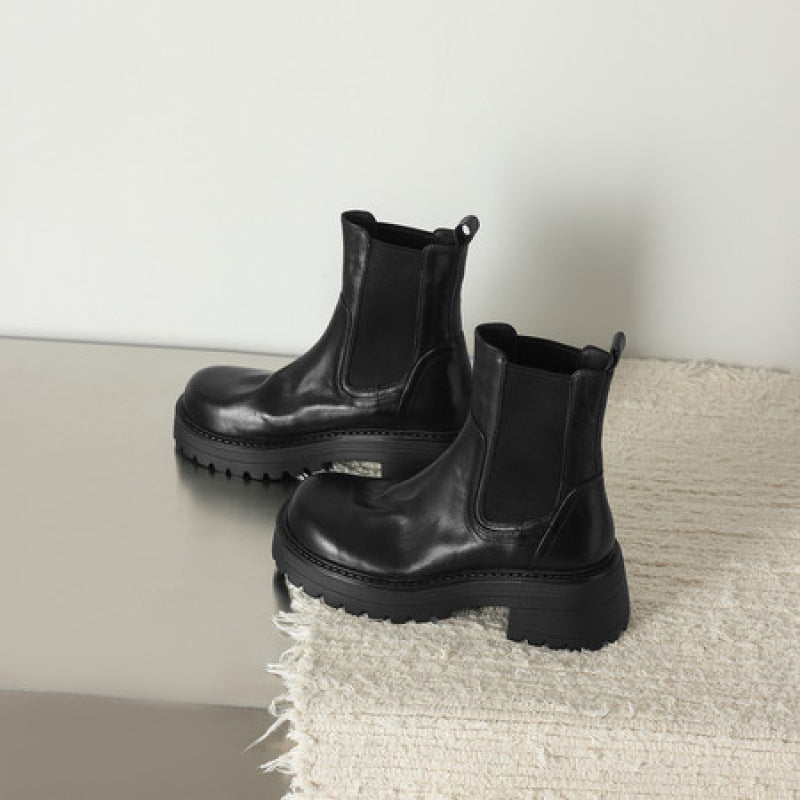 Pair of black leather Chelsea boots with elastic gore and chunky tread sole, round toe