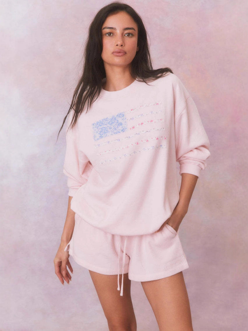 Light pink oversized crewneck sweatshirt with floral American flag stripes graphic