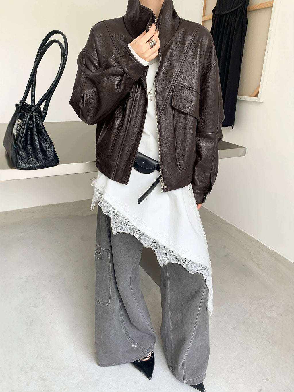 Cropped dark brown faux leather jacket with stand collar, zip front, and flap pockets