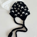 Laid-flat black knit star beanie with ear flaps and long braided tie strings.