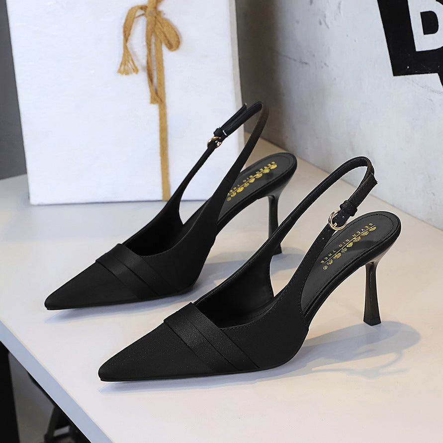 Black satin slingback heels with pointed toe, stiletto heel, and folded vamp band.
