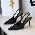 Black satin slingback heels with pointed toe, stiletto heel, and folded vamp band.