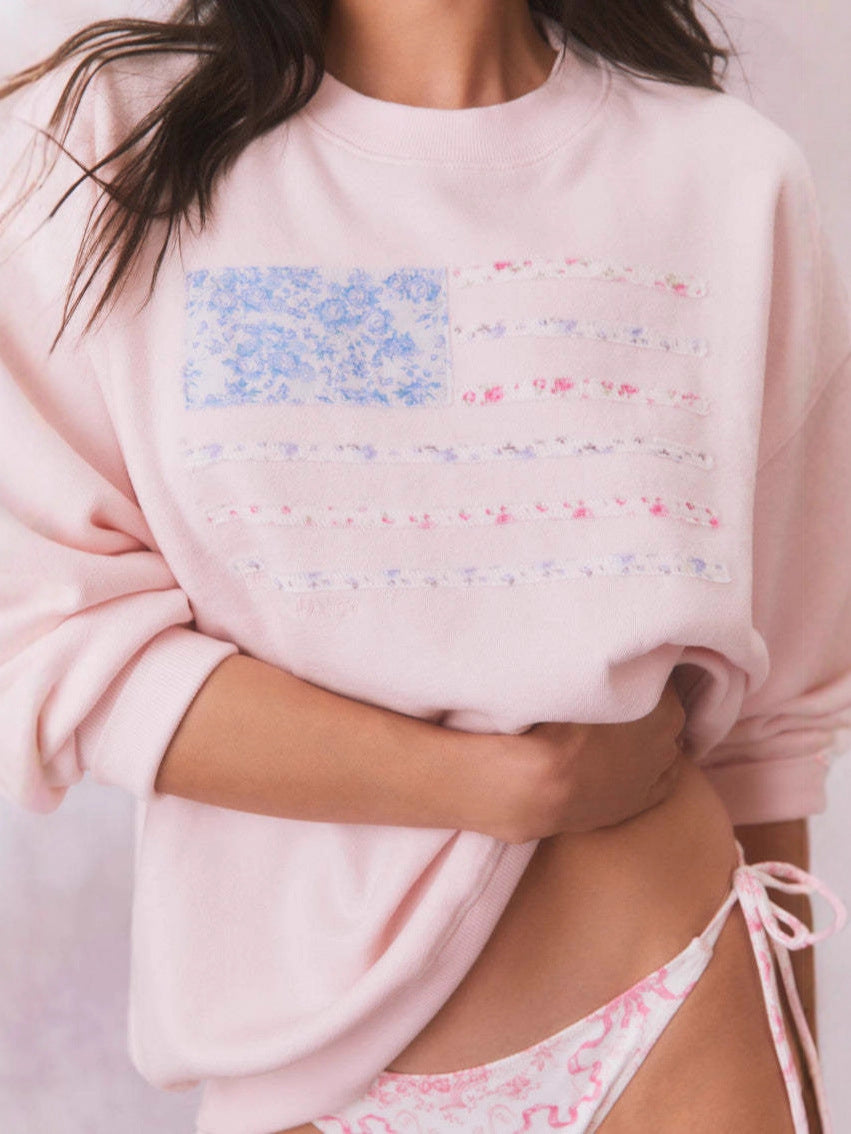 Light pink crewneck sweatshirt with floral American flag graphic detail at chest
