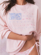 Light pink crewneck sweatshirt with floral American flag graphic detail at chest