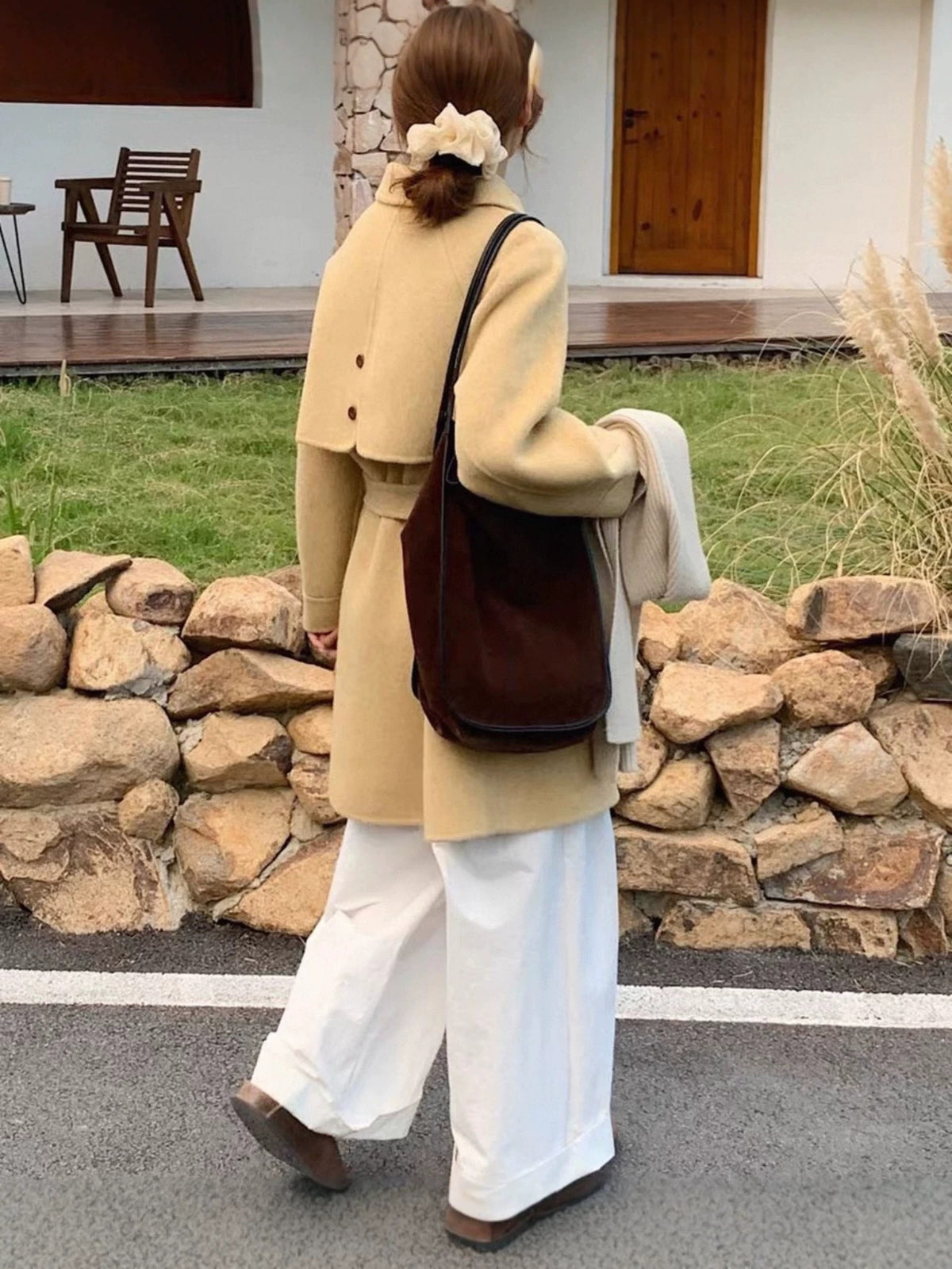 Camel wool coat seen from the back, with raglan sleeves and a waist belt