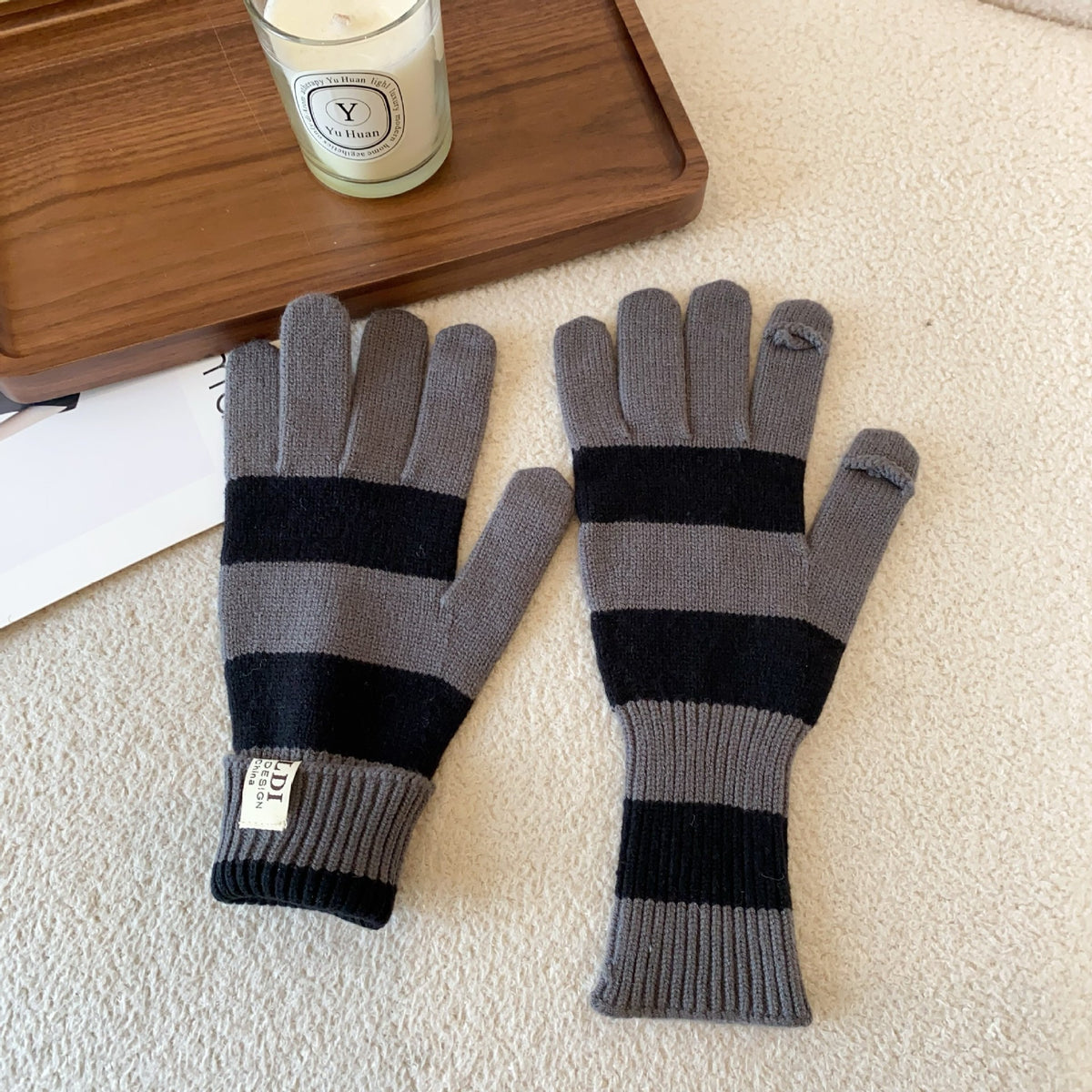 Women’s striped knit gloves in gray and black with long ribbed cuffs and five-finger design