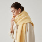 Oversized fuzzy mohair-blend scarf with fringe ends, light yellow, worn draped over shoulders