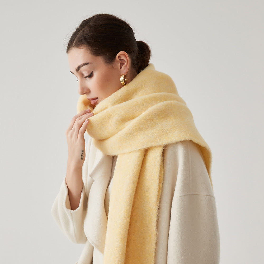 Oversized fuzzy mohair-blend scarf with fringe ends, light yellow, worn draped over shoulders