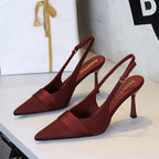 Burgundy satin slingback heels with pointed toe, stiletto heel, and folded vamp band.