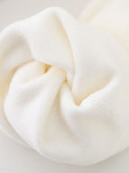 Close-up of off-white velvet fabric on a women’s hoodie