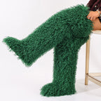 Green curly faux fur thigh-high boots, one leg extended.
