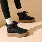 Black snow boots with drawstring collar and chunky tread sole