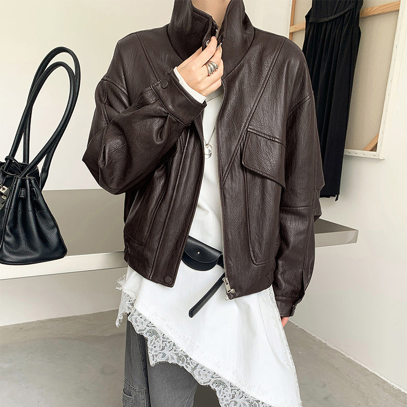 Cropped dark brown faux leather jacket with stand collar zip front, flap pockets, long sleeves