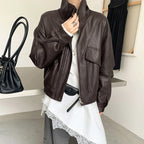 Cropped dark brown faux leather jacket with stand collar zip front, flap pockets, long sleeves