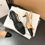 Black and beige slingback kitten heel pumps with bow accents and cap toes