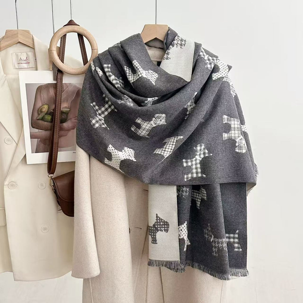 Gray dog-print blanket scarf with contrasting reverse and fringed ends, draped over a coat